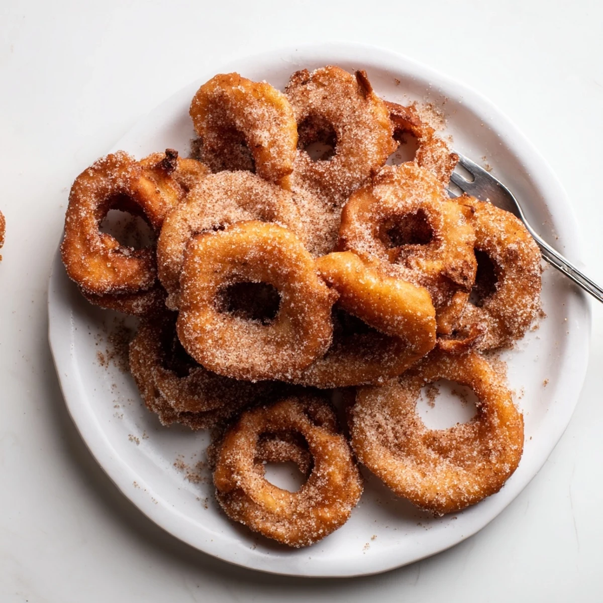 Krosse deutsche Apfelküchle, warm serviert mit Zimt-Zuckerbestreuung.  