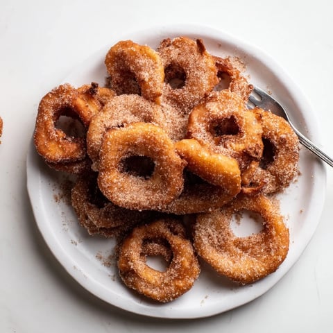 Krosse deutsche Apfelküchle, warm serviert mit Zimt-Zuckerbestreuung.  